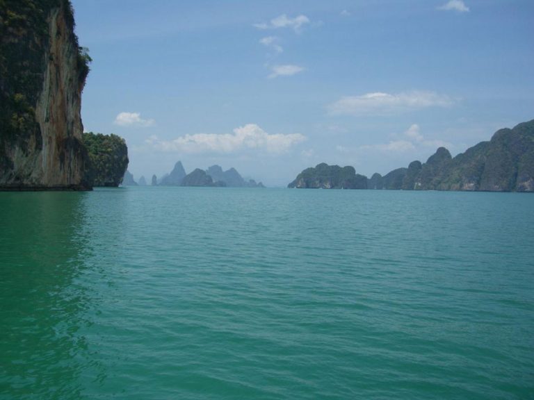 Kalksteinfelsen ragen aus dem türkisfarbenen Wasser der Phang-Nga-Bucht vor der Küste Thailands.
