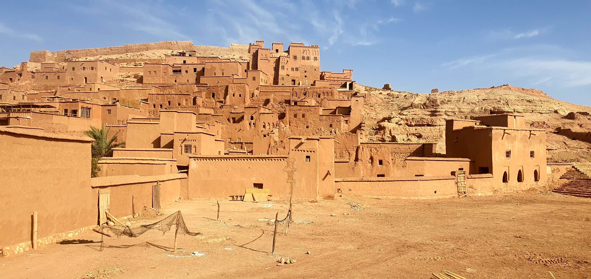 Ait Ben Haddou, eine Lehmziegel-Kasbah-Siedlung am Hang unter blauem Himmel in Marokko.
