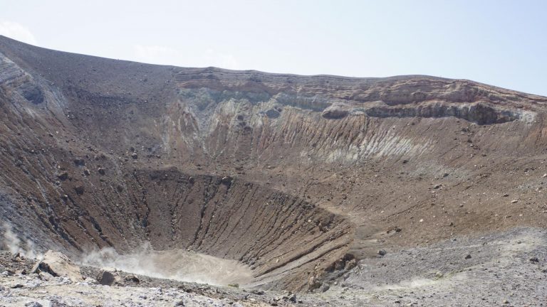 Vulkankrater mit erodierten Hängen und aufsteigendem Dampf auf Vulcano, Liparische Inseln.