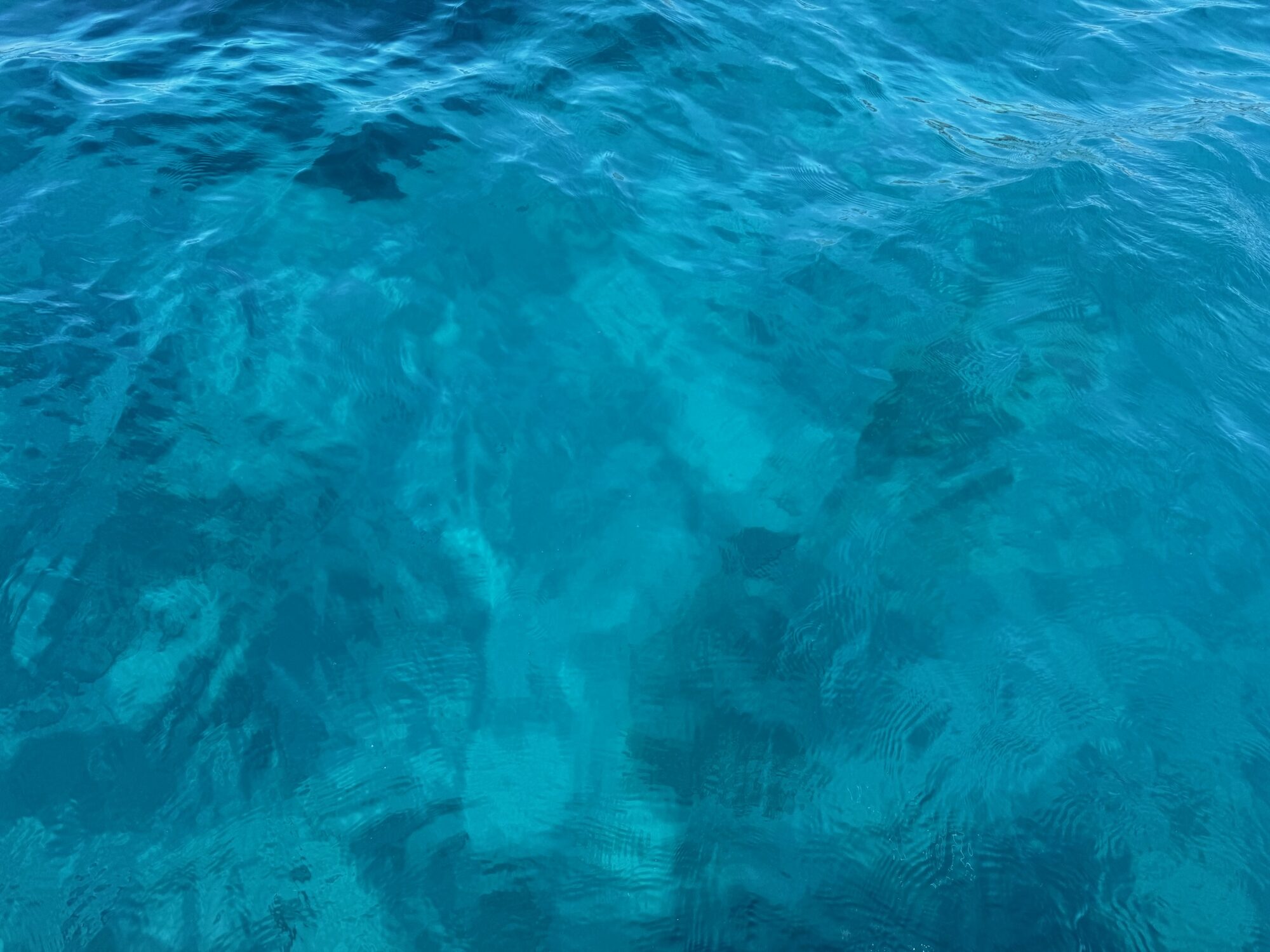 Klares türkisblaues Wasser der Marina Rubicón auf Lanzarote mit Blick auf den steinigen Grund.