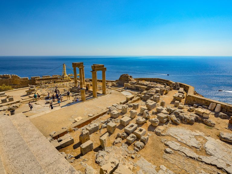 Antike Säulenruinen der Akropolis von Lindos auf Rhodos hoch über dem türkisblauen Meer.